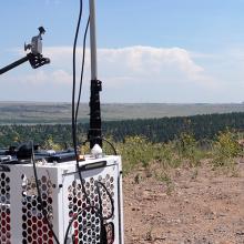 A FirstNet Compact Rapid Deployable on top of hill in Colorado in a rural area, the SUV that carried the CRD to the location is nearby