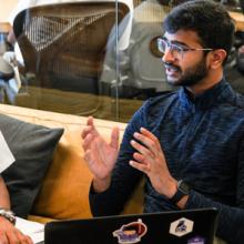 A firefighter sitting in an office with a programmer discussing public safety innovations