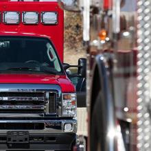 A red ambulance parked behind another public safety vehicle