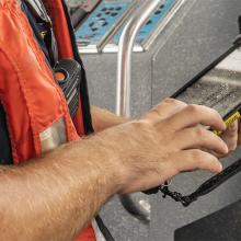 A Hyannis firefighter uses a tablet on a boat