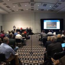 A full room of people listen to a FirstNet panel at an APCO conference