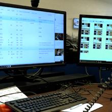 An emergency telecommunicator sits in front of computer monitor taking a call