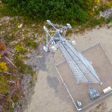 Overhead view of a Maine FirstNet cell tower in a rural area surrounded by trees.