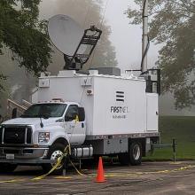 A FirstNet SatCOLT set up along a rural street on a foggy day.