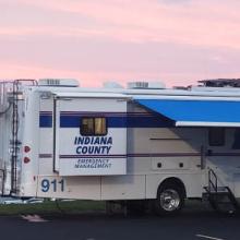 An Indiana County Emergency Management vehicle sits in a parking lot at sunset.