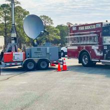 A FirstNet Compact Rapid Deployable and FirstNet, Fire & Rescue, and Police vehicles parked at Military Ocean Terminal Sunny Point, North Carolina A FirstNet Compact Rapid Deployable and FirstNet, Fire & Rescue, and Police vehicles parked at Military Ocean Terminal Sunny Point, North Carolina