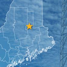 The State of Maine, with outlined county borders and star locating Millinocket, Maine; a cell tower.