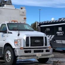 A FirstNet Satellite Cell on Light Truck and Communications Vehicle sit in a parking lot during the response to the Marshall Fire in Boulder County, Colorado 