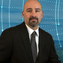 Meet the Tribal Liaison: Jasper Bruner advocates for Tribal public safety Jasper Bruner; a tree-covered hill with a broadband tower; an abstract design of interconnected circular lines and dotted lines radiation out from the center