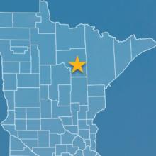 State of Minnesota with counties outlined; a star near Grand Rapids, Minnesota; a cell tower 