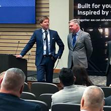 Members of the FirstNet Authority team stand facing a seated crowd of public safety professionals. 