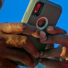 The game-changing benefits of push-to-talk for the fire service Close up of a smartphone in the hands of a public safety official