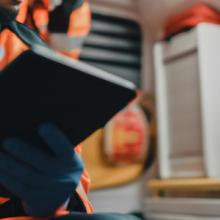 Emergency medical official using a tablet in the back of an ambulance