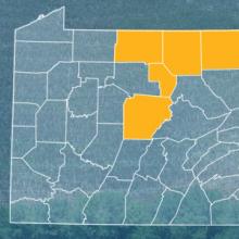 The state of Pennsylvania, with outlined county borders; a cell tower.