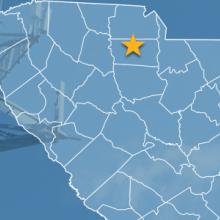The state of South Carolina, with outlined county borders and star locating Chester, South Carolina; a cell tower.