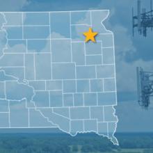 The state of South Dakota, with outlined county borders and star locating cell site; a cell tower.