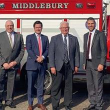 Local leaders and FirstNet Authority staff stand in front of a Middleburg ambulance