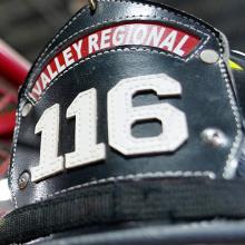 Valley Regional and Fire helmet on display in front of American flags