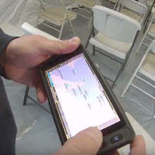 An officers holds a FirstNet device showing a app