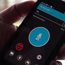 Hand holds FirstNet smartphone device with push-to-talk app displayed.