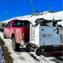 Firefighter holding FirstNet-enabled tablet speaks with FirstNet Authority representative; FirstNet compact rapid deployable is hitched to pickup truck and driven up snowy road; First responders uses virtual reality headset Firefighter holding FirstNet-enabled tablet speaks with FirstNet Authority representative; FirstNet compact rapid deployable is hitched to pickup truck and driven up snowy road; First responders uses virtual reality headset