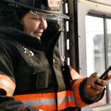 Firefighter using smartphone inside firetruck