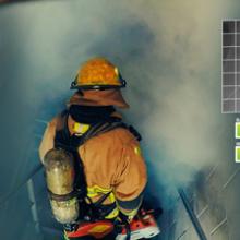 A firefighter in safety gear with a tank on his back descends stairs into a smoke filled area. A firefighter in safety gear with a tank on his back descends stairs into a smoke filled area.