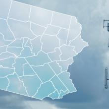 The state of Pennsylvania, with outlined county borders; star marking Hyndman in Bedford County; a FirstNet cell tower