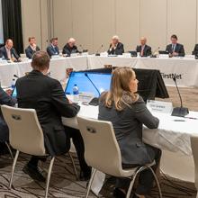 FirstNet Authority Board members sit at tables facing each other during a Board meeting 