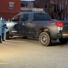 Medical professionals stand by a pickup truck at a COVID-19 testing site.