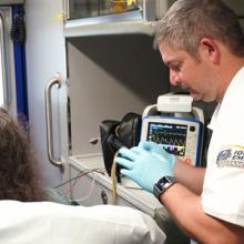 Emergency medical services personnel tend to a patient in an ambulance. Emergency medical services personnel tend to a patient in an ambulance.