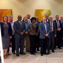 FirstNet Public Safety Advisory Committee members discuss matters during a meeting, Twenty-three representatives of all disciplines of public safety stand for a PSAC group photo