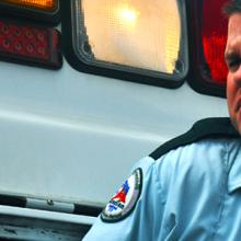 Emergency medical services professional stands in front of ambulance