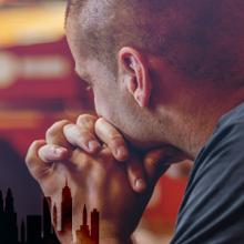 First responder somberly looking away; silhouette of New York City skyline with World Trade Center tower remembrance silhouettes First responder somberly looking away; silhouette of New York City skyline with World Trade Center tower remembrance silhouettes