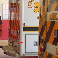 Franklin County EMS personnel walk behind ambulances inside fire station. . 