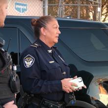 Ironton Police Department Chief Pamela Wagner and an Ironton police officer talk with Ironton Mayor Sam Cramblit outside of a police SUV cruiser.