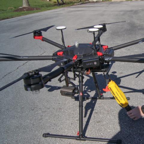 Police officer prepares drone on street; Public Safety First podcast logo; “Eyes in the Sky: Drones and FirstNet”