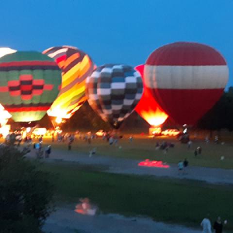 Hot-air balloon participate on a field glow at third annual FireLake Fireflight Balloon Festival in Shawnee, Oklahoma.
