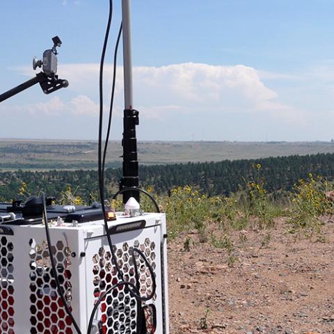 A FirstNet Compact Rapid Deployable on top of hill in Colorado in a rural area, the SUV that carried the CRD to the location is nearby