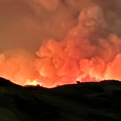 The 2024 Airport Fire burns just beyond the ridge of Southern California’s Santa Ana Mountains while heavy smoke fills the sky. 