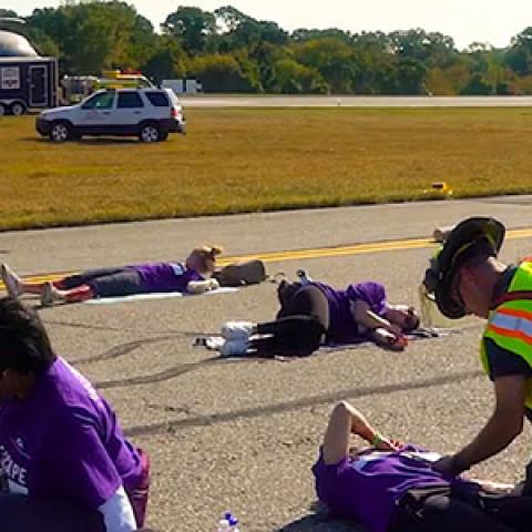 During a large-scale incident at an airport, first responders are attending crash victims on runway.