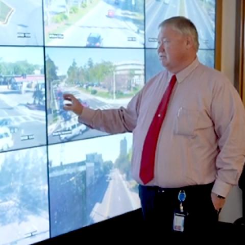 Public works staff from Gainesville, Florida consult several screens showing live stream video from around the city. 