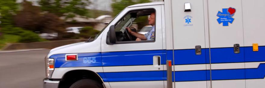 Bangs ambulance driver turning on a suburban road