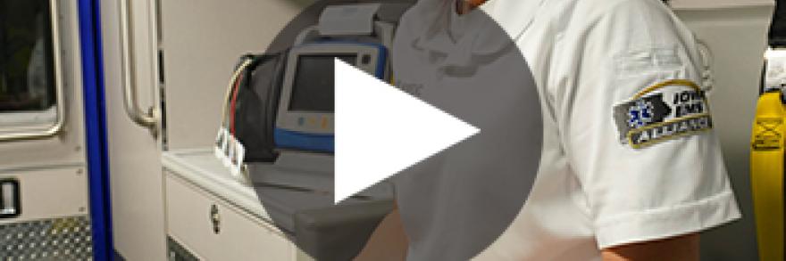 An EMS technician from the West Des Moines EMS team uses a smartphone in the back of an ambulance