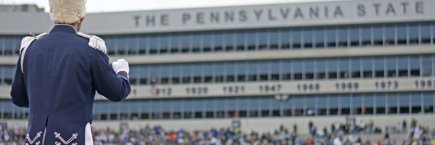 Band member standing in Beaver Stadium during daytime