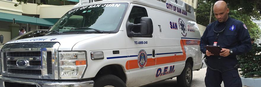First responder using a tablet while standing next to an ambulance
