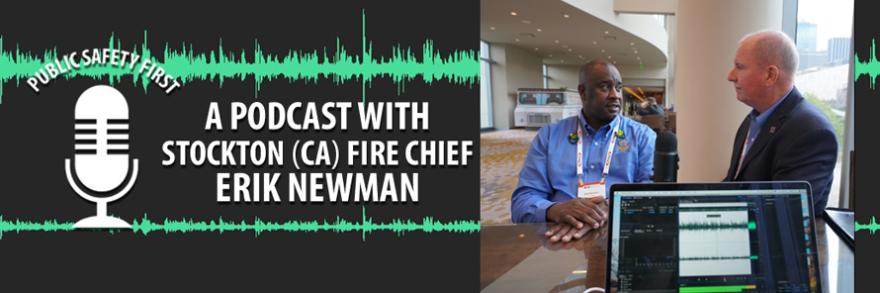 Chief Erik Newman and Dave Buchanan stand at a table together