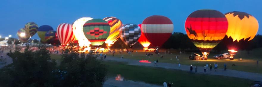 Hot-air balloon participate on a field glow at third annual FireLake Fireflight Balloon Festival in Shawnee, Oklahoma.