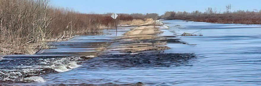 A road in Minnesota partially submerged in water from a recent flood. 