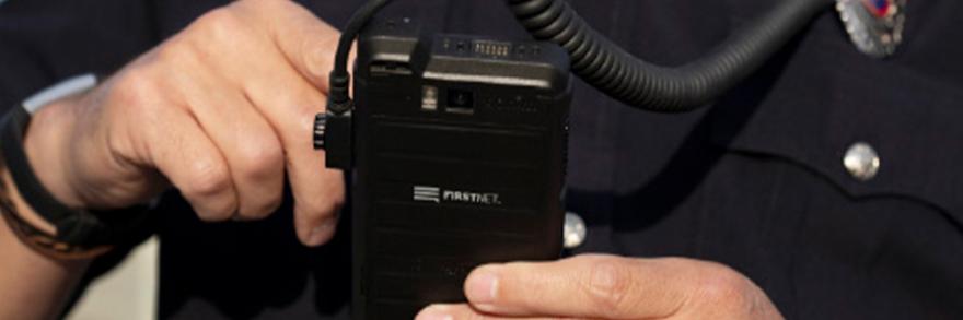A first responder using FirstNet Push-to-Talk on a ruggedized smartphone
